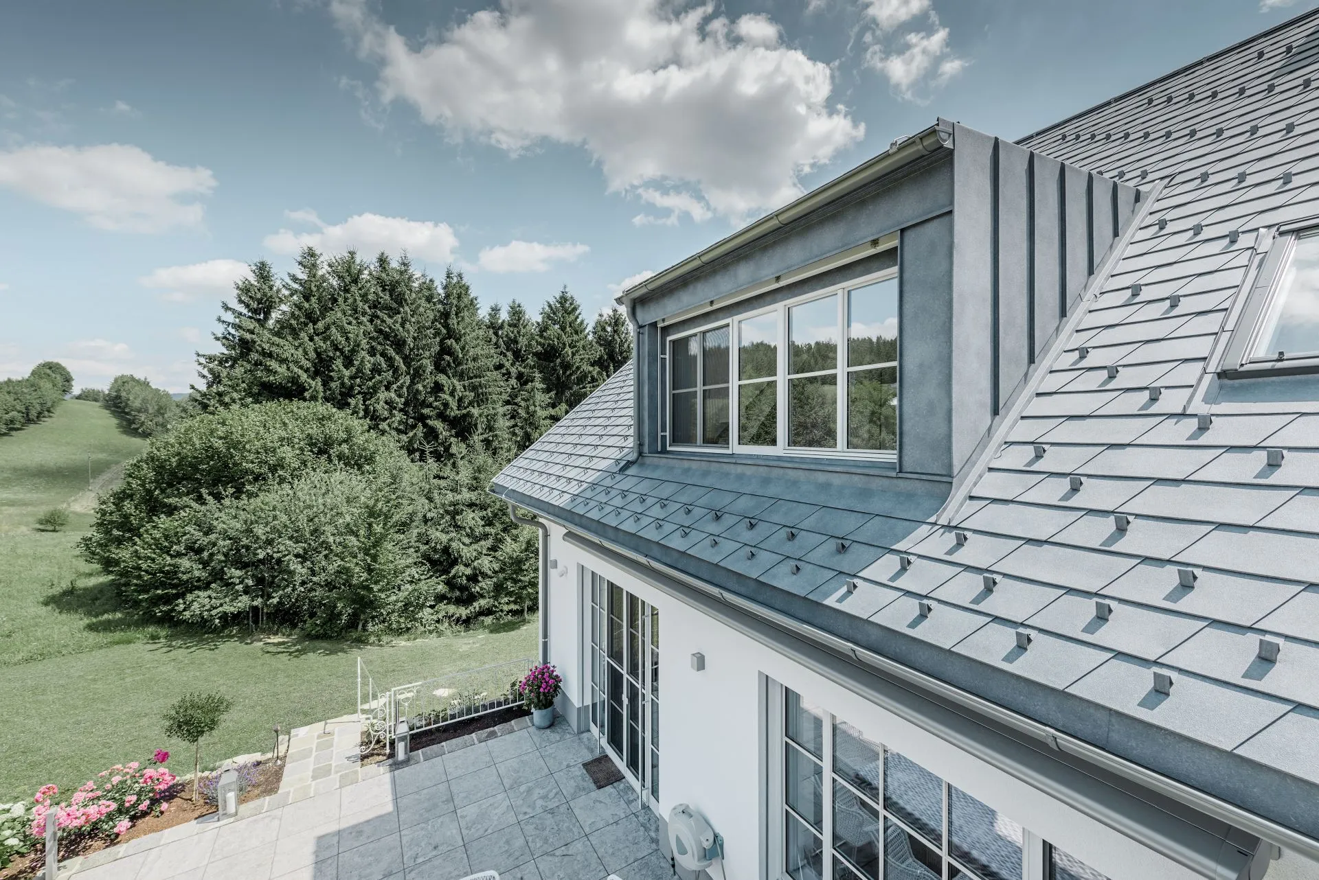 Modernes Bauernhaus mit Dachgiebel und Alubedachung.