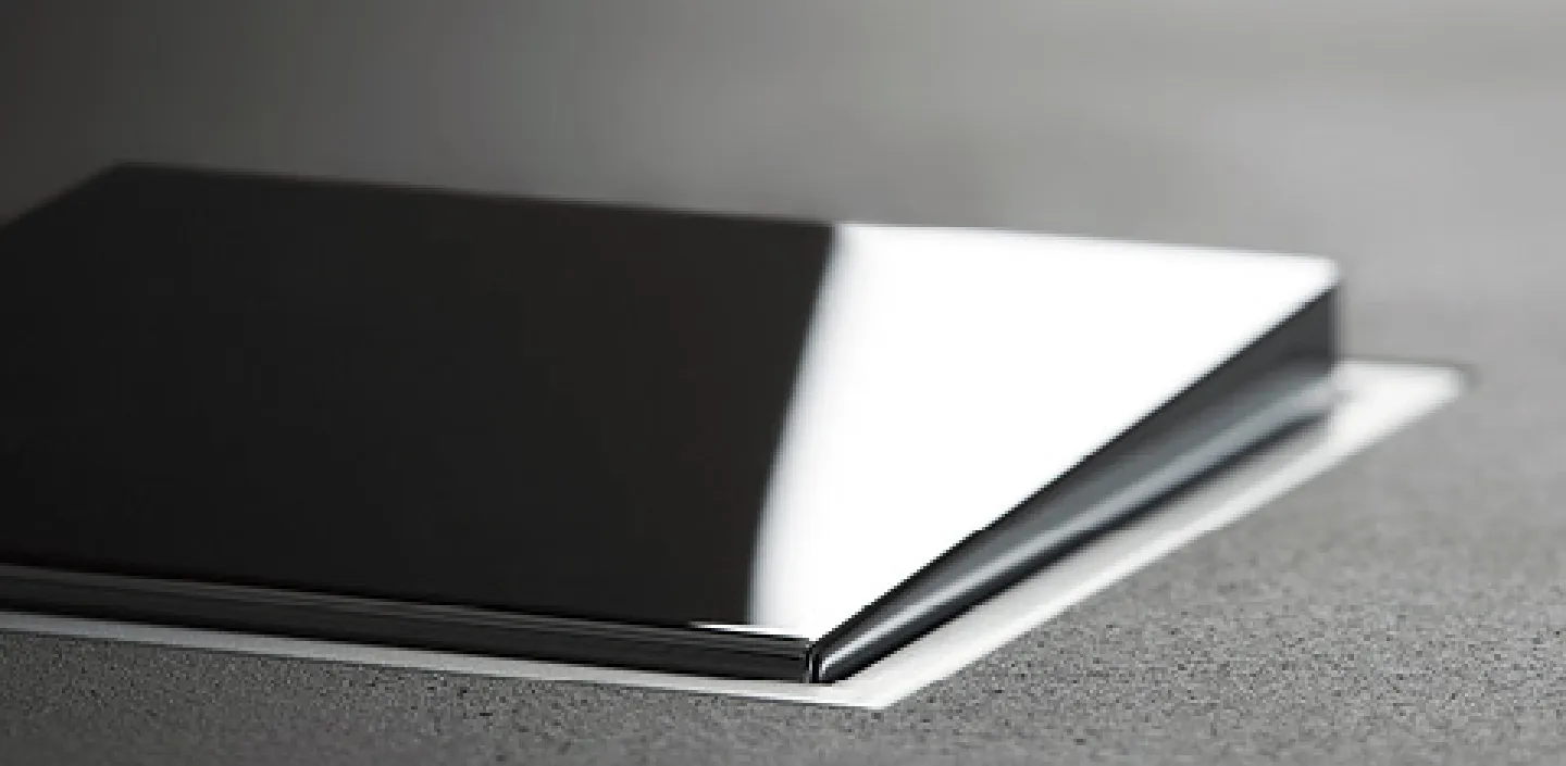 Ein schwarzer, glänzender Schalter der Serie JUNG LS-Zero ist bündig in eine graue Wand eingelassen, wodurch ein nahtloses Design entsteht.