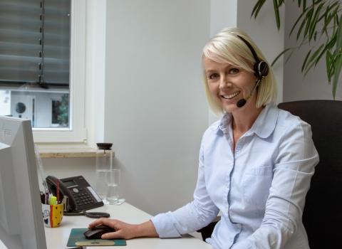 Bürokauffrau mit Headset in einem SHK-Handwerksbetrieb.