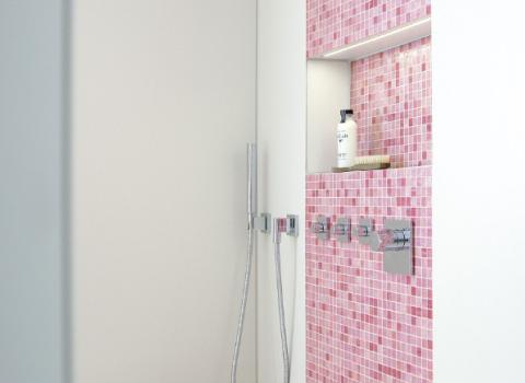 Eine Dusche mit rosa Mosaik-Fliesen und Accessoires.