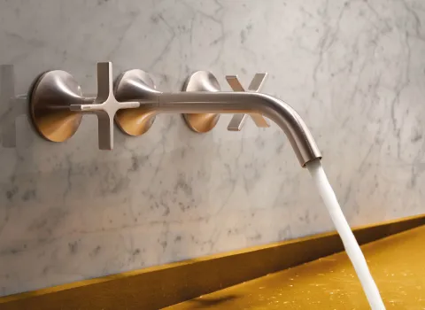 Nahaufnahme der stilvollen Wandarmatur Tara von Dornbracht in einem luxuriösen Badezimmer, montiert an einer Marmorwand. 