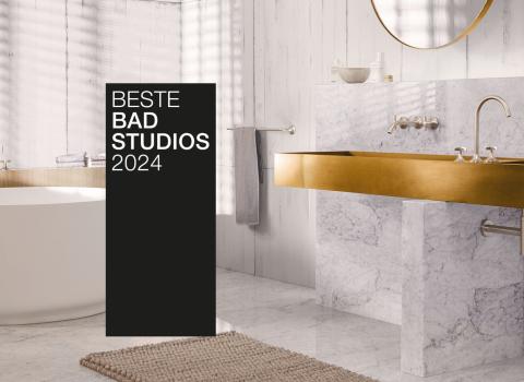 Ein stilvolles Bad mit goldenen Armaturen, Marmorwaschtisch und freistehender Badewanne. Ein schwarzer Banner mit "Beste Badstudios 2024" ist prominent im Bild.