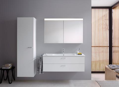 Die Badmöbelserie XBase von Duravit zeigt einen weißen Waschtisch mit Spiegelschrank, Hochschrank und einem stilvollen, hellen Interieur.