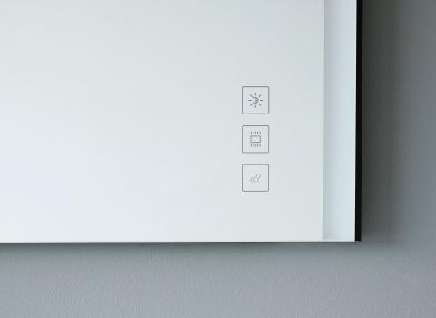 Detailansicht eines beleuchteten Spiegels mit drei Touch-Symbolen für Licht, Heizung und Spiegelentnebelung.