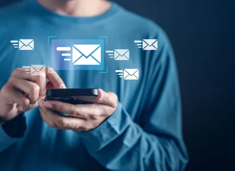 Eine Person nutzt ein Smartphone, während digitale Symbole für E-Mails erscheinen und einen Newsletter-Versand darstellen.