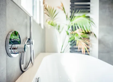 Nahaufnahme Badewanne mit Unterputz-Wannenarmatur in Chrom.
