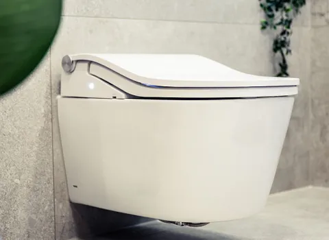 Detailaufnahme eines modernen, wandhängenden Dusch-WCs mit abgerundeter Form und elegantem Design.