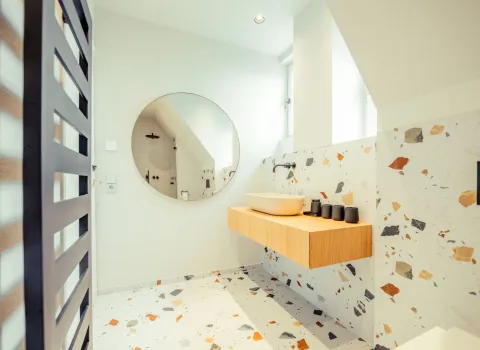 Helles Designer-Badezimmer mit Terrazzo-Fliesen in bunten Farbtönen erstreckt sich über Wand und Boden.
