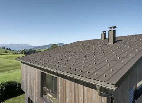 Aludach von Prefa auf einem Landhaus vor malerischer Naturkulisse.