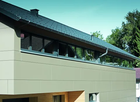 Massives Haus mit Holz- und Metallelementen in weiß-grau-hellbraunen Farbtönen.