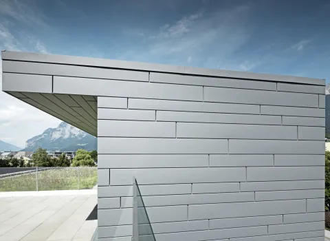Seitenprofil eines modernen Gebäudes mit Alufassade mit freistehender Überdachung.