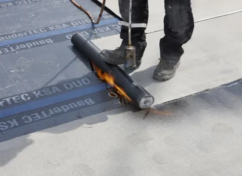 Flaschner verlegt Flachdachabdichtung von Bauder.