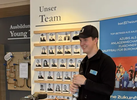 Ein Auszubildender der Firma Vitus König steht am Infostand im Firmengebäude.