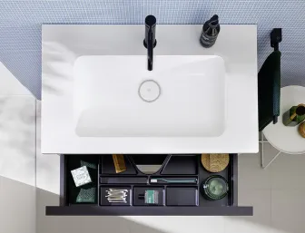 Von oben fotografierts Badezimmerwaschbecken der Eqio-Serie mit einer schwarzen Armatur und einer geräumigen Schublade zur Aufbewahrung.