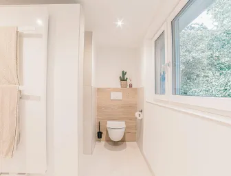 Seckler WC in hellem Bad mit Eichenfront im hinter der Toilette.