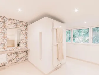 Modernes und helles Badezimmer mit Schminkplatz und kunstvoller Tapete mit Gräsern.