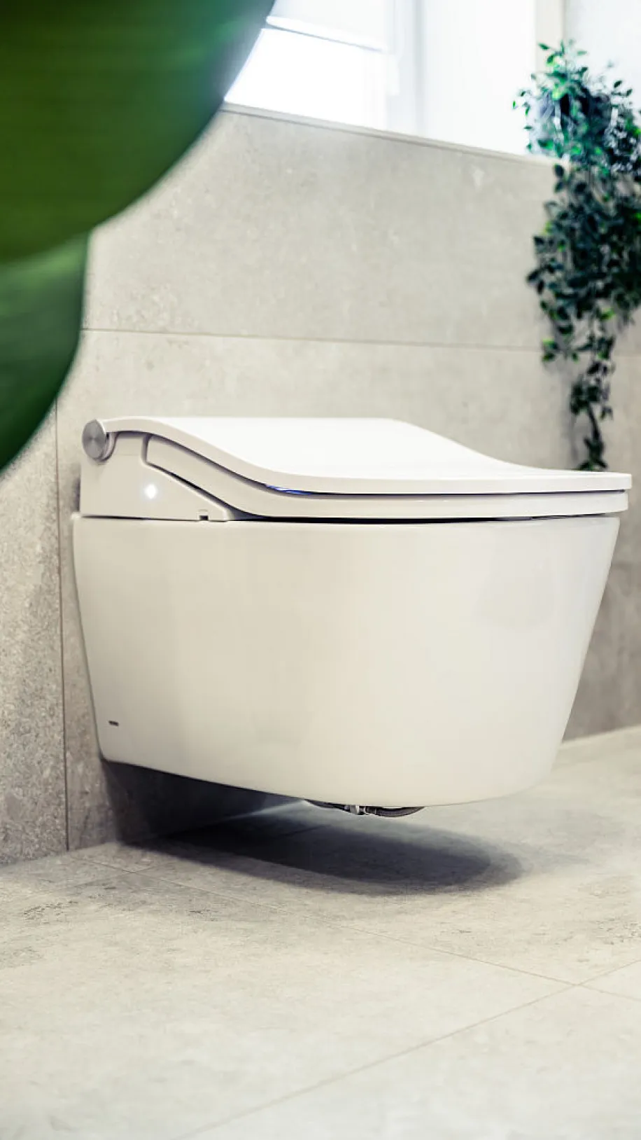 Detailaufnahme eines modernen, wandhängenden Dusch-WCs mit abgerundeter Form und elegantem Design.