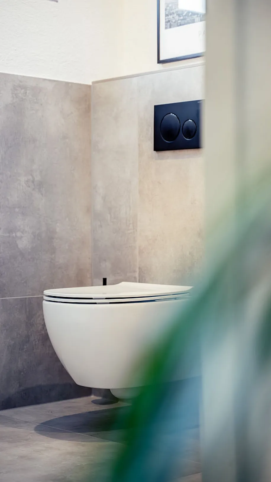 Nahaufnahme des WCs mit schwarzem Bedienfeld mit zwei unterschedlichgroßen Spülungstasten.