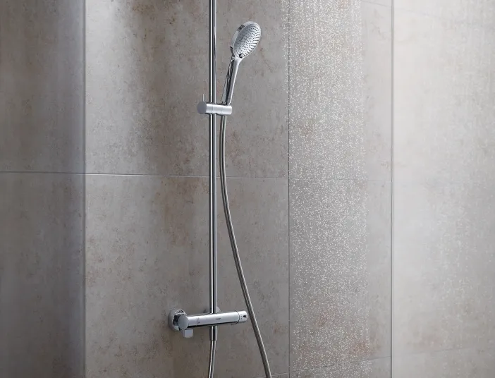 Ein Duschsystem mit glänzender Aufputzarmatur, bestehend aus einem Duschkopf und einem flexiblen Brauseschlauch, installiert an einer beigen Fliesenwand.