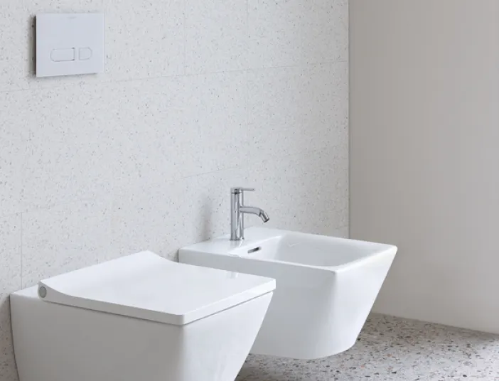 Helles Badezimmer mit weißer Keramik-Toilette und Bidet von Duravit, flankiert von einer großen Fensterfront, die das helle und offene Design betont.