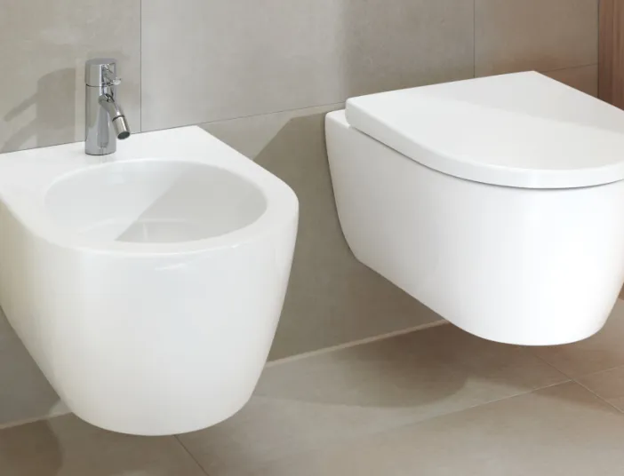 Ein modernes Badezimmer mit einem wandmontierten WC und einem passenden Bidet, beide in schwebender Anordnung. 