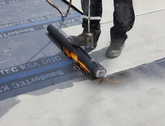 Flaschner verlegt Flachdachabdichtung von Bauder.